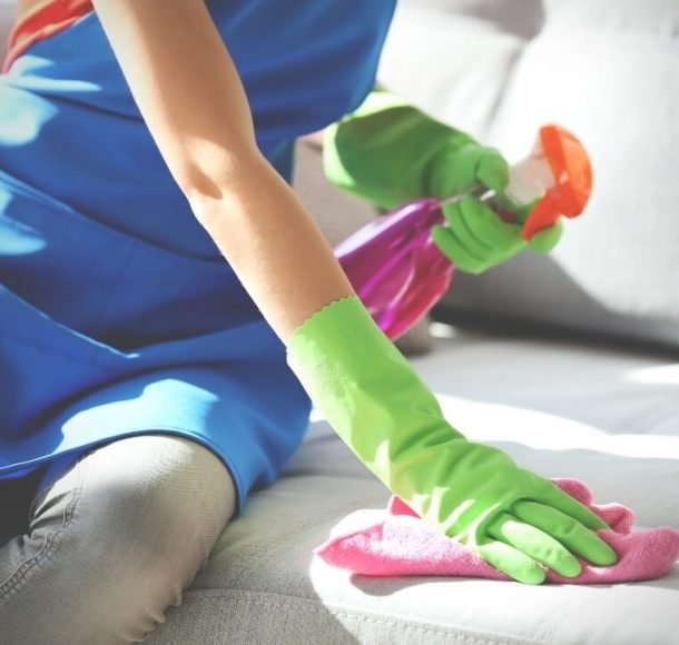 Woman cleaning a sofa. Orchid Cleaning Services
