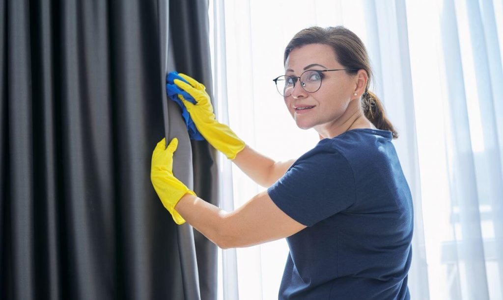 cleaner expert removing dust from curtains