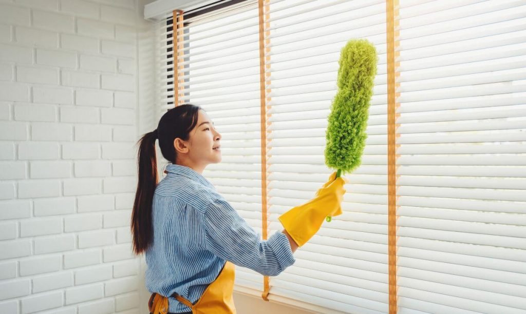 Lady remove dust from curtains