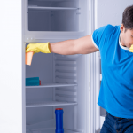 Man smelling bad edors with his fridge.