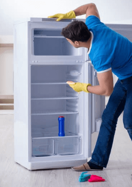 Guy cleaning the inside of the fridge Orchid Cleaning Services