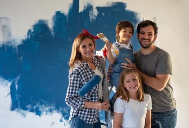 Cleaning | Family painting a wall of color blue